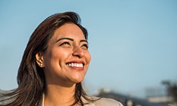 A closeup of a Latina woman smiling sideways