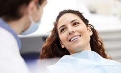 A smiling young woman looking at her dentist