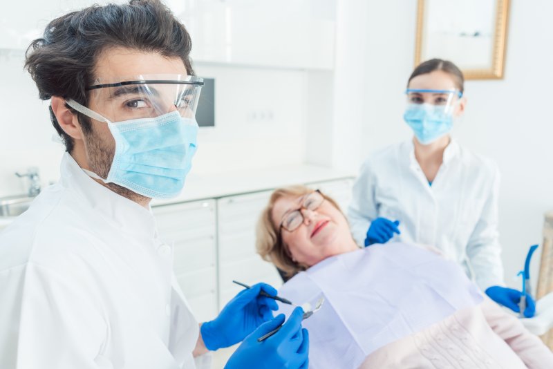 Dentist in Greenfield wearing PPE with patient 